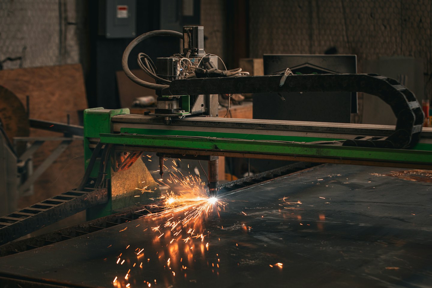 Cięcie plazmowe CNC tworzące iskry na arkuszu metalu.